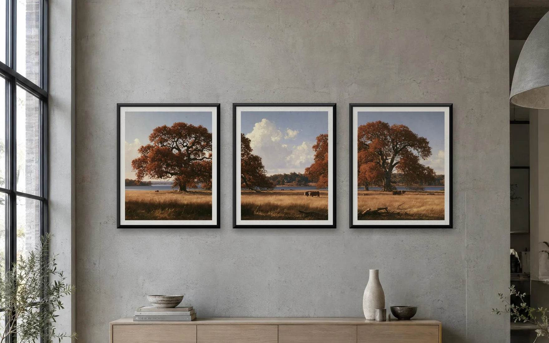 A gallery wall listing: three framed autumn landscapes hung side by side above a sideboard